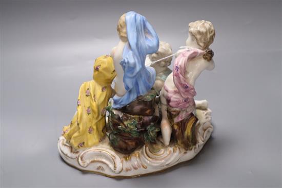 A 19th century German porcelain figure group of four semi-draped youths beside a fire, width 21cm